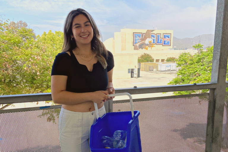 Student poses with deskside bin